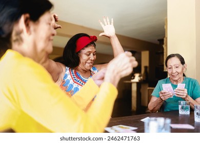 Happy senior women having fun playing cards at home. Elderly people life style - Powered by Shutterstock