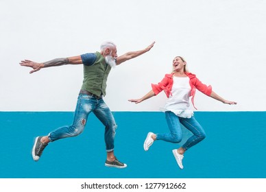 Happy Seniors Crazy Couple Jumping Together Outdoor - Mature Trendy People Having Fun Celebrating And Dancing Outside - Concept Of Happiness, Freedom, Carefree, Love And Relationship