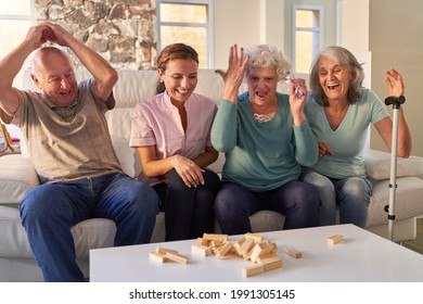 Happy Seniors In Family Play Jenga At Game Night At Home