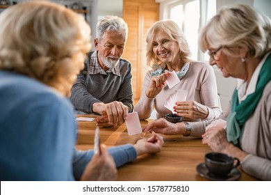 Happy seniors having fun while playing card game at home.  - Powered by Shutterstock