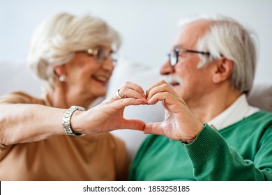 Happy Seniors Posing With Holding Hands And Smiling. Relationships, Love And Old People Concept - Close Up Of Senior Couple Showing Hand Heart Gesture