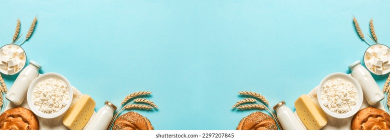 Happy Shavuot - Religious Jewish holiday concept with dairy products, cheese, traditional bread, milk bottles, wheat  on blue background, copy space, banner. - Shutterstock ID 2297207845