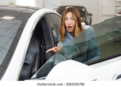 Happy Shocked Woman Customer Female Buyer Client Wears Blue Shirt Open Door Chooses Auto Wants To Buy New Automobile In Car Showroom Vehicle Salon Dealership Store Motor Show Indoor. Sales Concept.