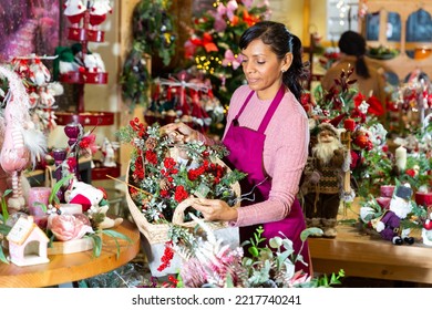 Happy Shop Owner Preparing A Large Basket With Christmas Flowers And Gifts