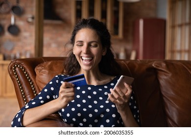 Happy Shopaholic Woman Excited With Buying Good On Internet Stores, Paying For Purchase By Credit Card, Using Banking App On Smartphone For Payment. Online Shopper Overjoyed With Good Cashback