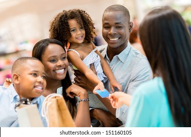 Happy Shopping Family At The Cashier Paying For Their Purchases