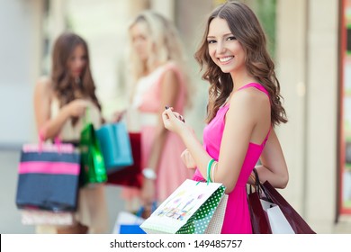 Happy Shopping-Frau mit einer Gruppe von Freunden auf dem Hintergrund