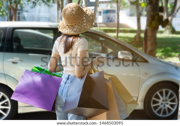 Happy shopping woman hold shopping bags on the\
street.She enjoy in life style shopping concept,in midnight sales\
and discount on sales.