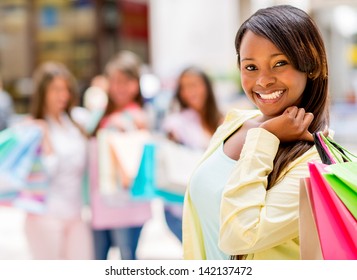 Happy shopping woman smiling at the mall holding bags