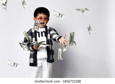 Happy Shouting Self-confident Asian Rich Kid Boy Millionaire Standing With Bunch Of Moneys Throwing Money Dollars Cash. Overspend. White Background