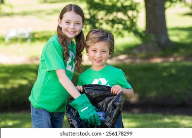 Happy siblings collecting rubbish on a sunny day