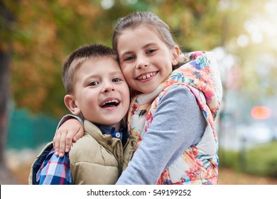 Happy siblings hugging outside - Powered by Shutterstock