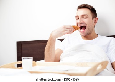 Happy Single Man Eating Breakfast In Bed