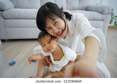 Happy Single Mom Hugging Daughter Selfie Together. Cute Smiling Daughter Having Fun Taking Pictures With Lovely Asian Mother, Warm Relationship, Mother And Child.