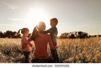 Happy single mother daughter son moment in nature sunset  - Shutterstock ID 2259591301