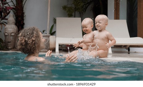 Happy Single Parenthood. Young Mom Playing With Her Twin Babies At The Private Swimming Pool