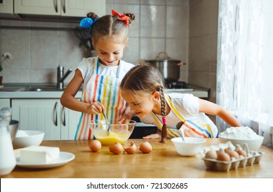 happy sisters children girls bake cookies, knead dough, play with flour and laugh in the kitchen
 - Powered by Shutterstock