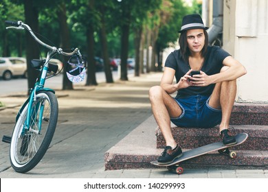 Happy skateboarder sitting on stairs. Young active people. Outdoors - Powered by Shutterstock