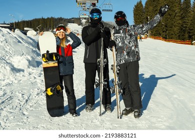 Happy Skiers In Mountain Resort In Sunny Day