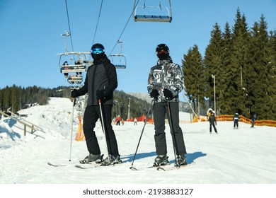 Happy Skiers In Mountain Resort In Sunny Day