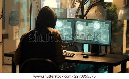 Happy skilled man planning security breach to take important information without authorization. Male hacker doing espionage and breaking into computer system with dark web. Handheld shot.