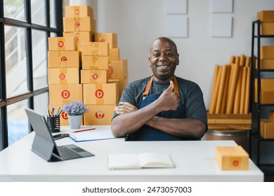 Happy small business owner in apron giving thumbs up in modern office with cardboard boxes, laptop, and notepad. - Powered by Shutterstock