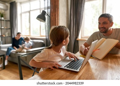 Happy Smart Little Girl Child Study Online On Computer Prepare School Task Assignment With Father At Home. Caring Dad Help Small Teen Daughter With Homework, Learn On Laptop. Distant Education.