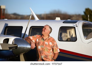 a happy, smart and well to do man stands proudly next to his latest airplane and looks to the sky to decide if he wants to fly to paris for French Fries
