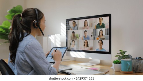 Happy smile asia young talent woman learn mba college class on webcam video call in desktop screen with cowork friend workforce group talk in sale report. Smart job work at home for staff workspace. - Powered by Shutterstock