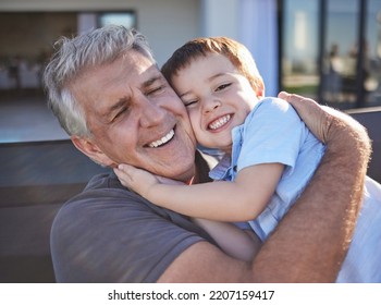 Happy, Smile And Grandfather Hugging His Grandchild While Playing Together At The Family Home. Happiness, Playful And Elderly Man In Retirement Embracing And Bonding With His Toddler Grandson.