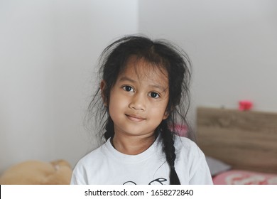 Happy Smile Of Young Women, 7 Years Old, Asian People, Thailand After She Woke Up In The Bedroom On Her Holiday But Her Hair Is Very Messy