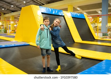 Happy smiling 11 years old kids jumping on trampoline indoors in entertainment center. Active children leisure, jumping and playing on trampoline in sport center. Amusement park. Sport activity. - Shutterstock ID 1910397580