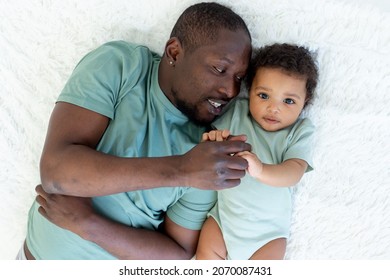 Happy Smiling African American Dad With Baby Son On Bed At Home Cuddle, Happy Family, Father's Day