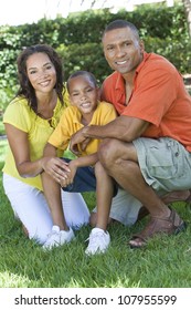 A Happy, Smiling African American Family, Mother Father & Son, Man Woman & Child, Outside In Summer Sunshine.