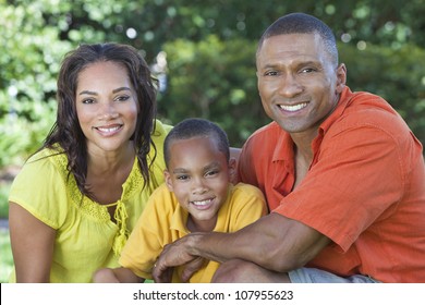 A Happy, Smiling African American Family, Mother Father & Son, Man Woman & Child, Outside In Summer Sunshine.