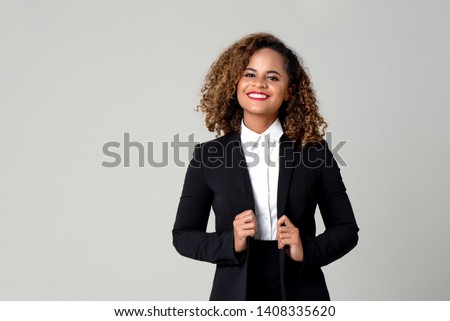 Happy smiling African American woman in formal business attire isolated on gray background