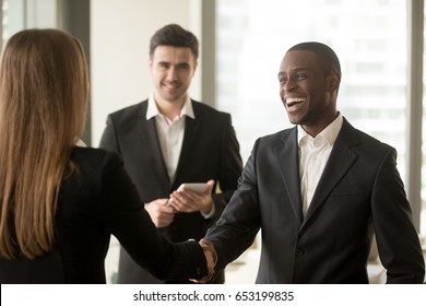 Happy Smiling Afro American Businessman And Caucasian Businesswoman Shaking Hands Standing In Modern Office, Nice To Meet You, First Impression, Congrats, Promoted To The Post, Reward Accomplishments