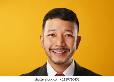 Happy Smiling Asian Business Man Headshot Portrait Isolated On Yellow Background