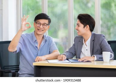 Happy Smiling Asian Customer Old Man Showing OK Sign With Young  Salesman Closing Deal About Contract, Life Insurance, Bank Loan, Banking, Finance, Health Care In The Office, Retirement Concept.