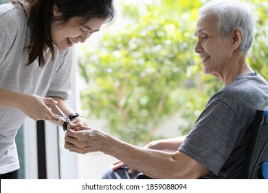 Happy smiling asian daughter cutting fingernail,manicure with nail clipper,help support to cleaning of finger nail for disabled senior mother in wheelchair,hygiene care,kindness,concern and gratitude - Powered by Shutterstock