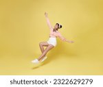 Happy smiling asian girl relaxing floating in mid-air isolated on yellow background.