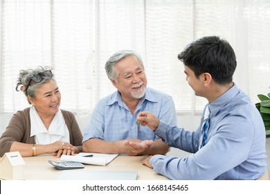 Happy smiling Asian mature couple satisfy and receiving key house from real estate agent, older parent making property purchase contract agreement, concept for retirement or lifestyle insurance
