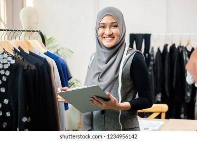 Happy Smiling Asian Muslim Woman Designer As A Startup Business Owner Working In Her Tailor Shop