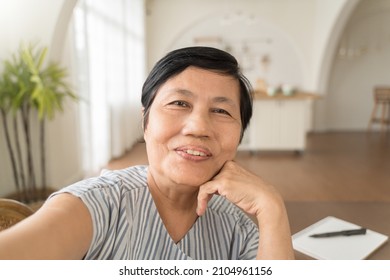 Happy smiling Asian senior woman using mobile phone taking selfie at home, Grandmother making video call on smatphone. - Powered by Shutterstock