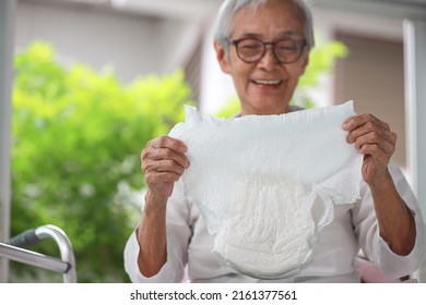 Happy Smiling Asian Senior Woman Showing Disposable Diaper For Adult,looking At Nappy Pamper With Satisfaction,old Elderly Patient With Urinary Incontinence,consumer Goods,health Care Concept