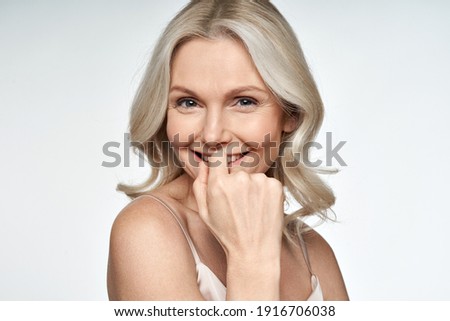 Happy smiling attractive 50s middle aged blonde woman looking at camera advertising antiage face skin and aging hair care treatment and cosmetics isolated on white background. Close up portrait.