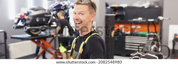 Happy smiling\
auto mechanic or locksmith with clipboard in workshop. Car service\
and maintenance transport\
concept