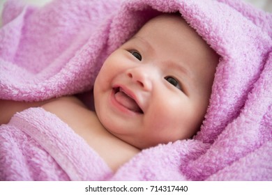 Happy And Smiling Baby After Bath With Towel On Head, Closeup