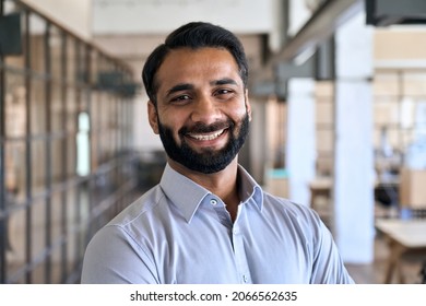 Happy smiling bearded indian business man small business owner, company leader or sales manager, male hispanic ceo executive, successful lawyer looking at camera standing in office, headshot portrait.