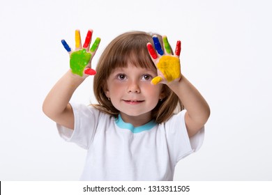 Happy smiling beautiful little girl with her colorful hands in the paint isolated on white background